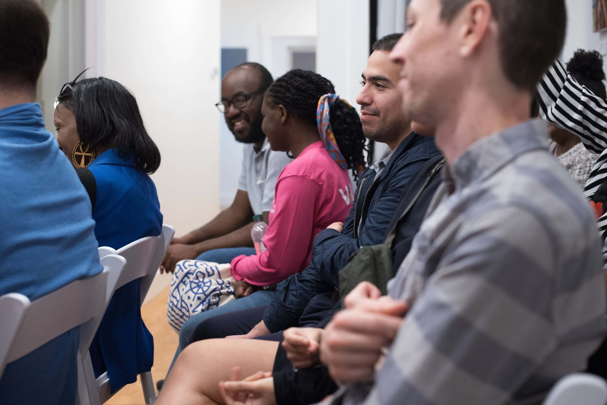 People sitting attentively during an event at The 7 Space, a hub for art and wellness activities.