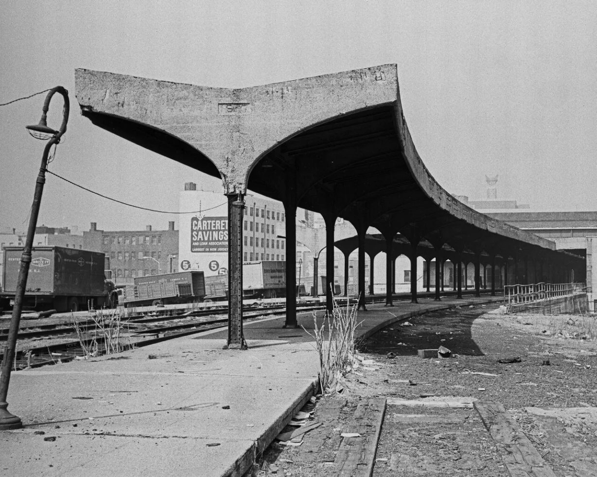 Old train station platform with curved canopy and railway tracks in Newark.
